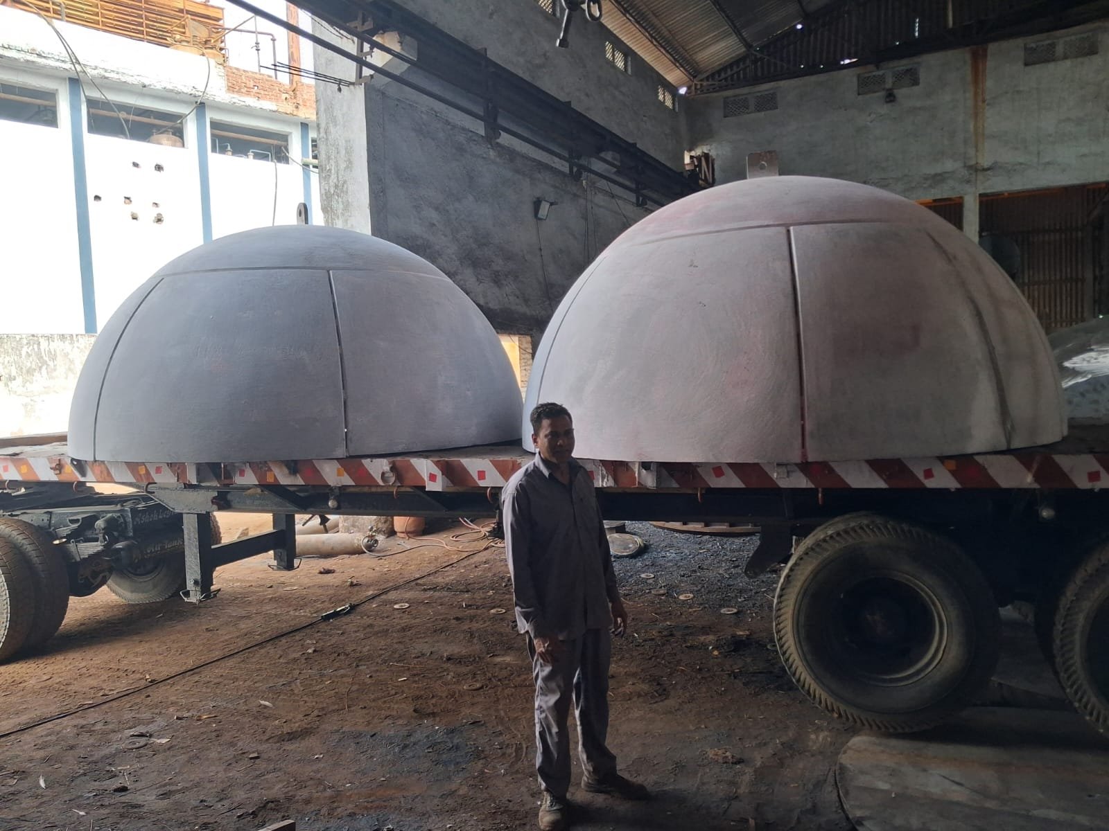 Two large petal-constructed hemisphere dished ends on trailer